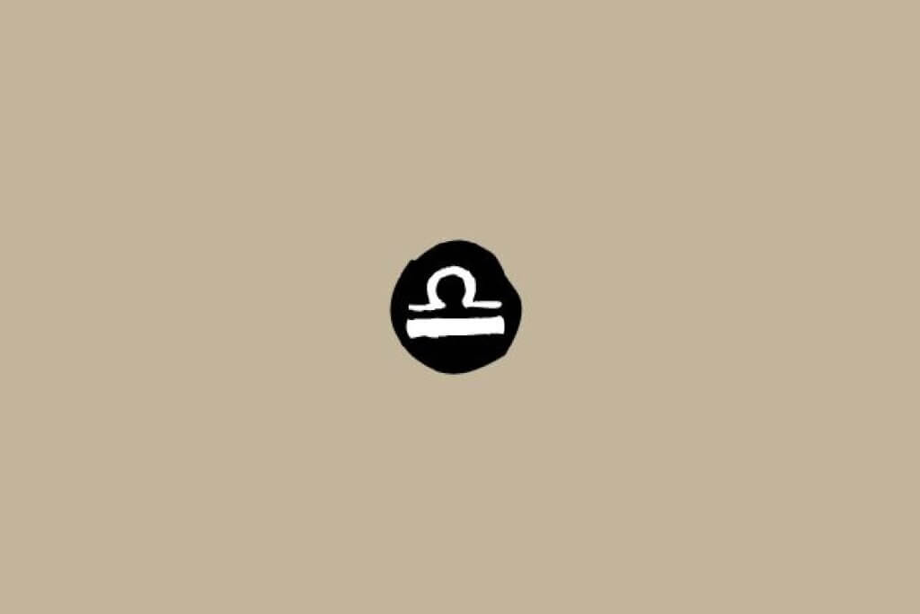 Símbolo do signo de Libra em branco dentro de um círculo preto sobre um fundo bege