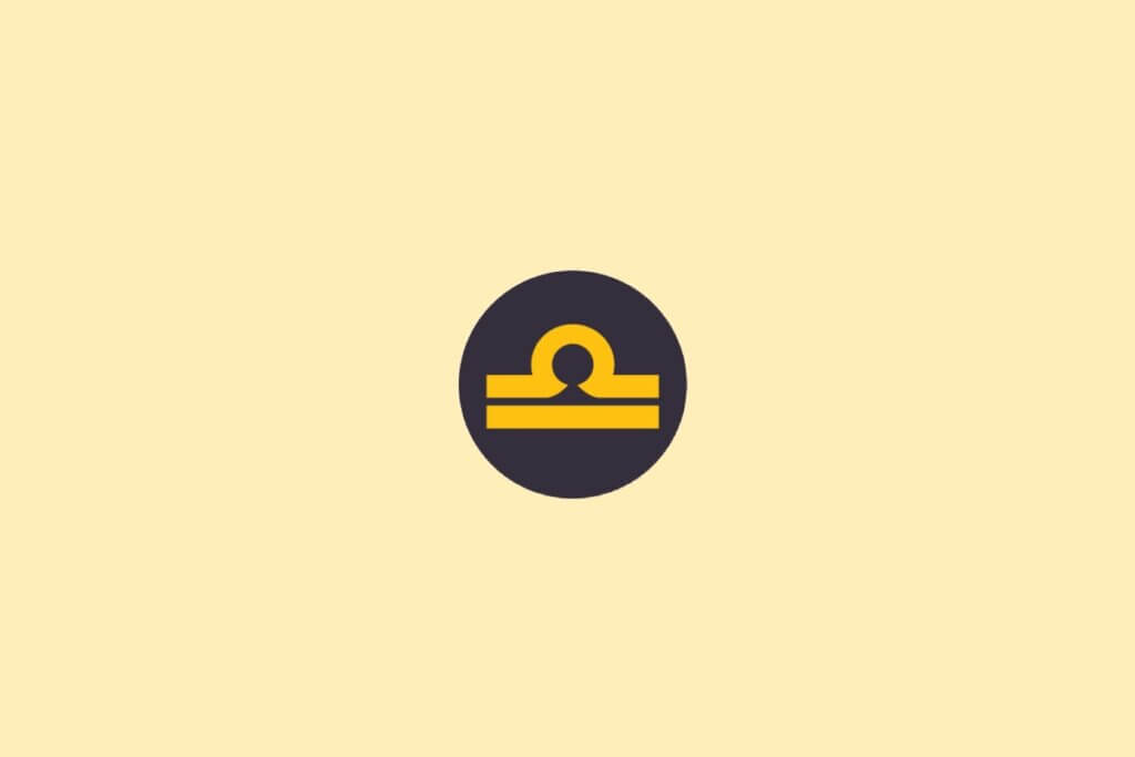 Um símbolo do signo de Libra em amarelo, dentro de um círculo escuro, sobre um fundo claro bege