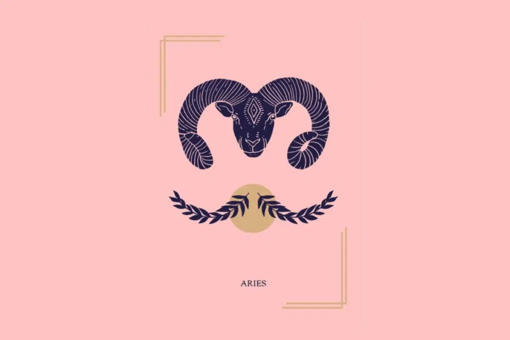 Ilustração mística sobre fundo rosa com a palavra "ARIES" na parte inferior. Ao centro, a cabeça de um carneiro com grandes chifres espiralados, posicionada acima de dois ramos folheados e um círculo dourado.