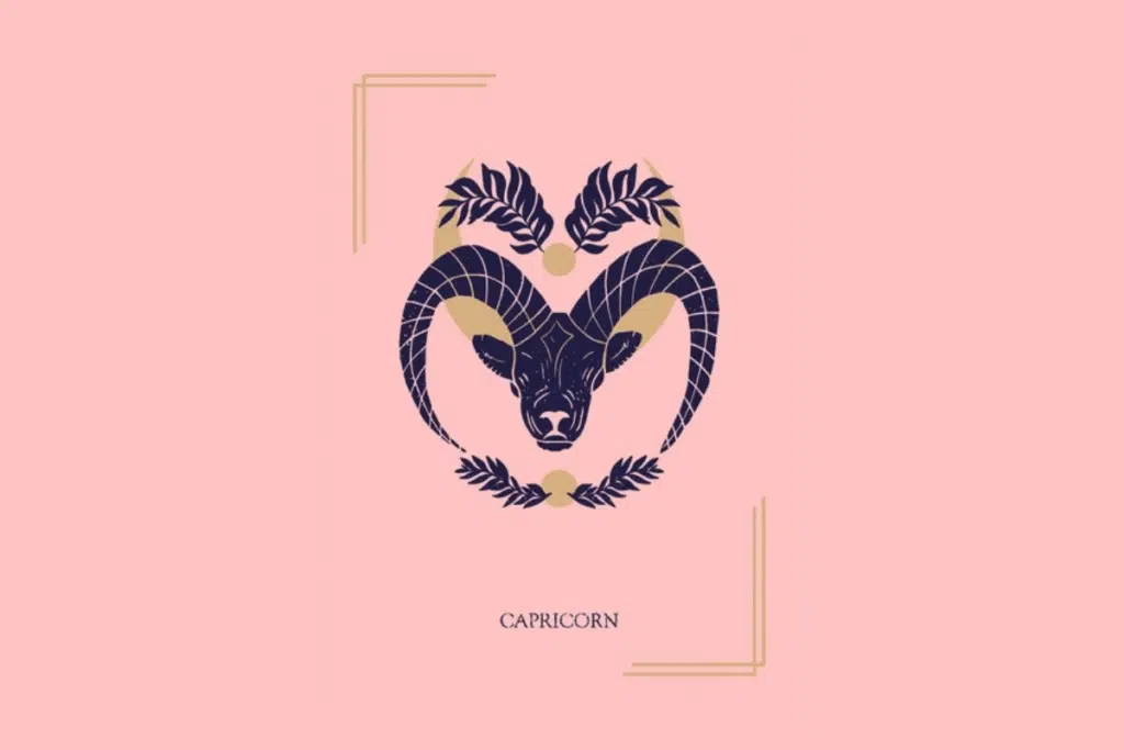 Ilustração mística sobre fundo rosa com a palavra "CAPRICORN" na parte inferior. Ao centro, a cabeça de uma cabra com chifres curvados decorados, emoldurada por uma lua crescente e ramos de folhas.