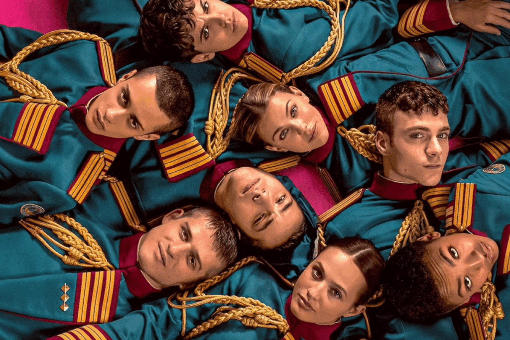 Imagem promocional de "Escola Minerva" mostrando vários jovens dispostos em círculo vista de cima, todos vestindo uniformes militares em tom verde-azulado com detalhes dourados e vermelhos