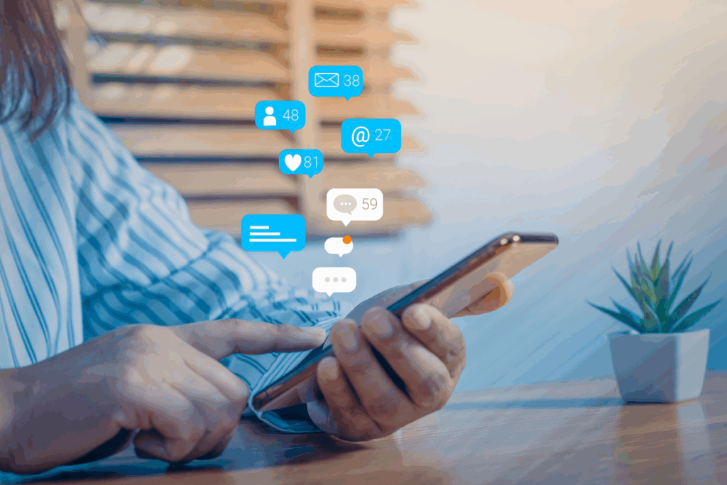 Pessoa utilizando um smartphone enquanto diversas notificações de mensagens, e-mails e redes sociais aparecem ao redor da tela.