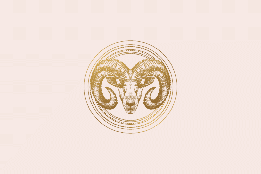 Ilustração do signo Áries: gravura dourada da cabeça de um carneiro vista de frente, com grandes chifres enrolados em espiral, dentro de um medalhão de anéis dourados finos e pontilhados; em fundo rosa-claro.
