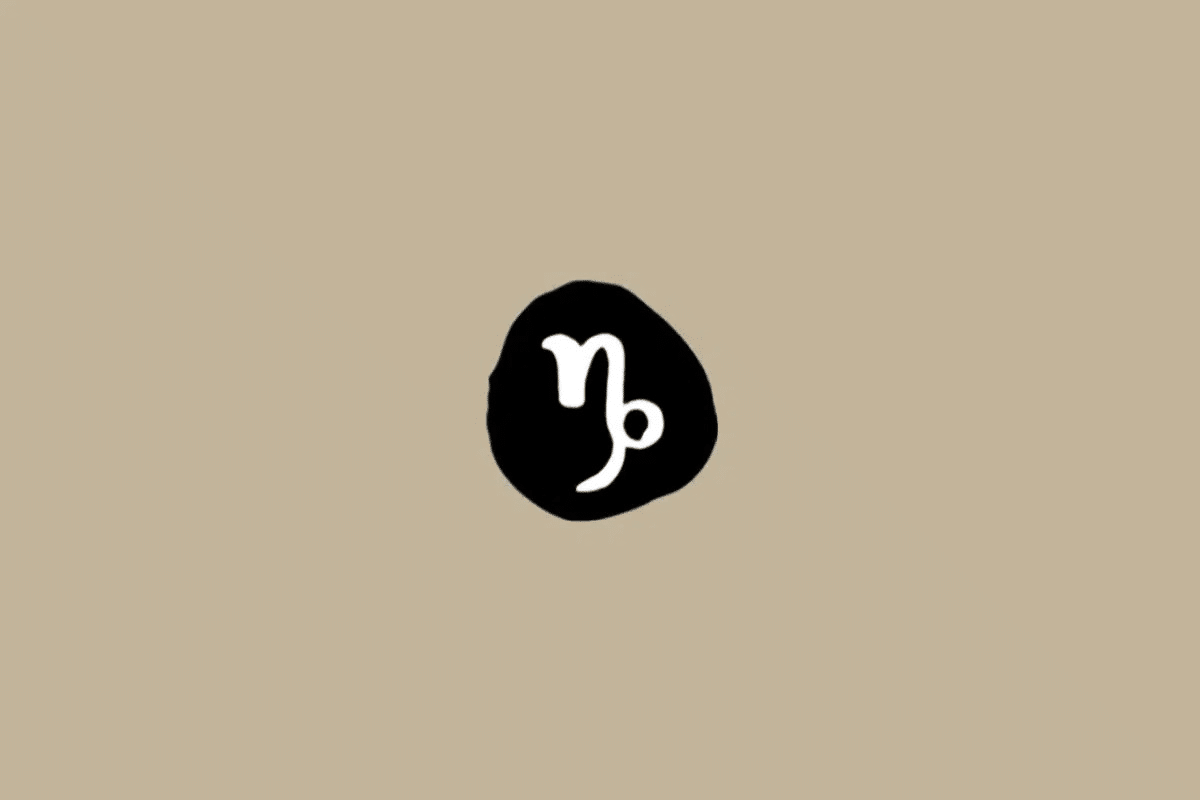 Símbolo do signo de Capricórnio em branco dentro de um círculo preto sobre um fundo bege 