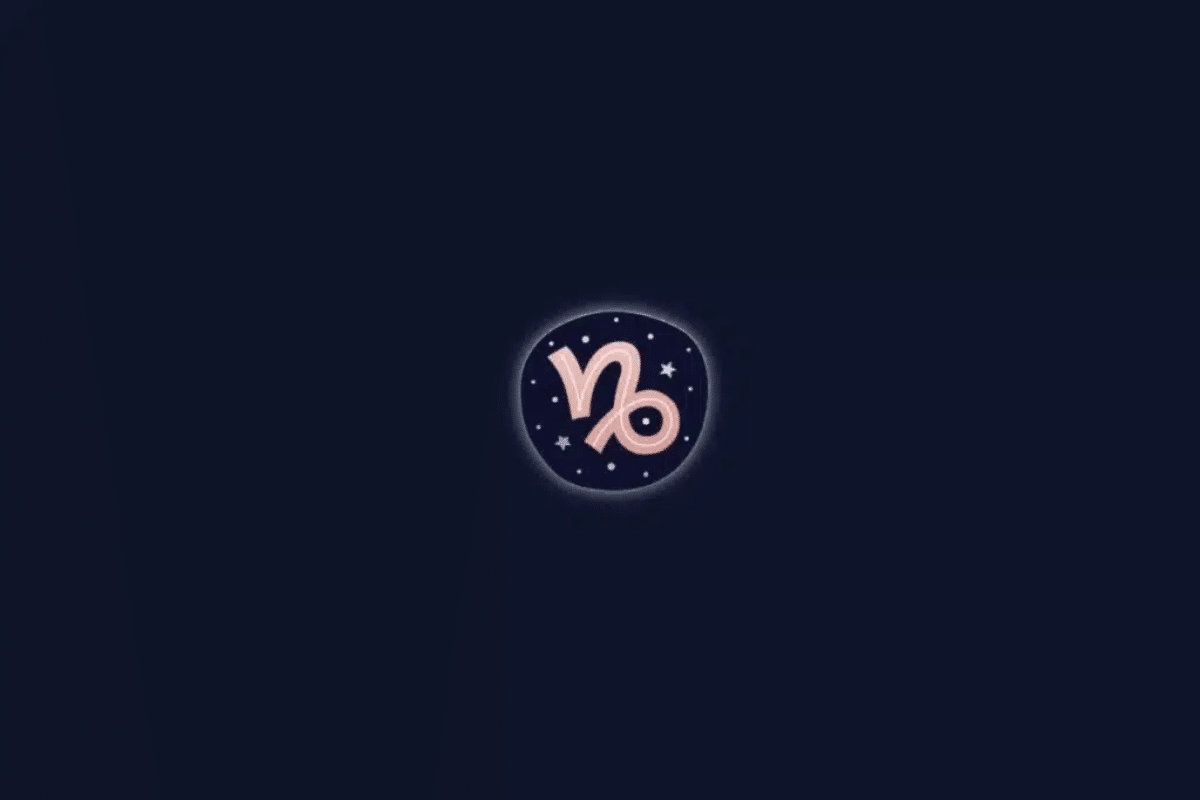 Ilustração do símbolo astrológico do signo de Capricórnio em tom de rosa-claro, centralizado em um círculo com pequenas estrelas brancas e um brilho discreto ao redor. O fundo é azul-marinho escuro.