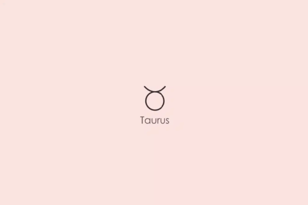 Ilustração minimalista do símbolo astrológico do signo de Touro, formado por um círculo com duas linhas curvas na parte superior, semelhantes aos chifres de um touro, em tom escuro. Abaixo, aparece a palavra “Taurus”, em inglês. O fundo é rosa-claro.